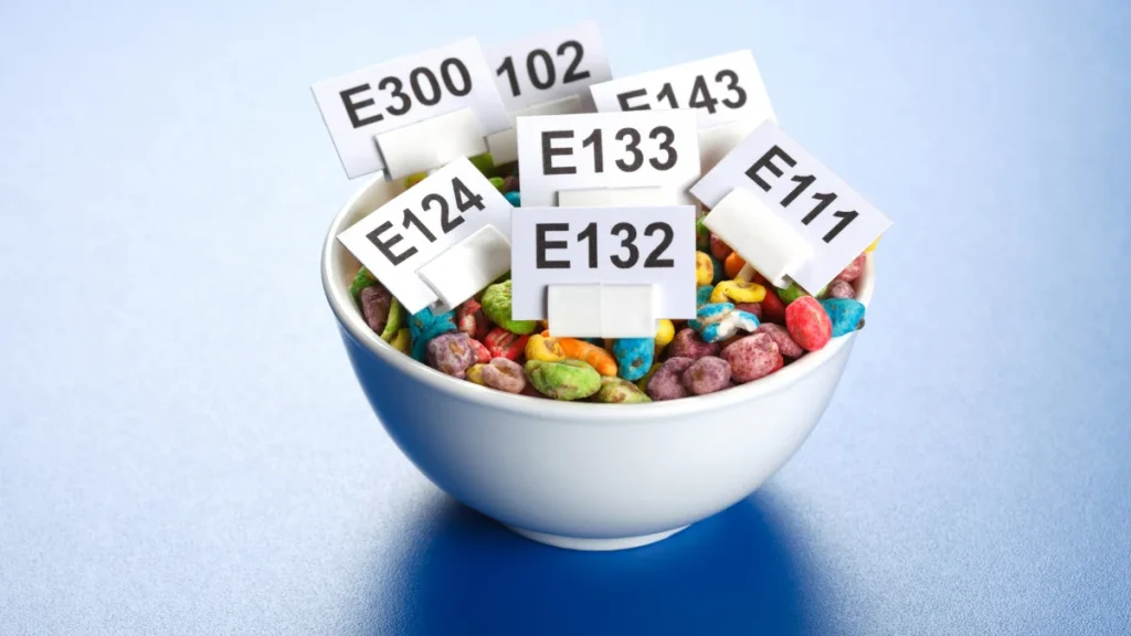 Colorful cereal bowl labeled with E additives like E132, E133, E124