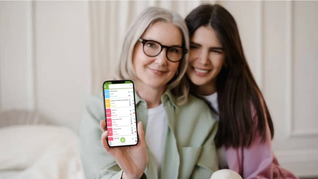 Deux femmes souriantes montrant l’application AvoidAdditives sur un smartphone